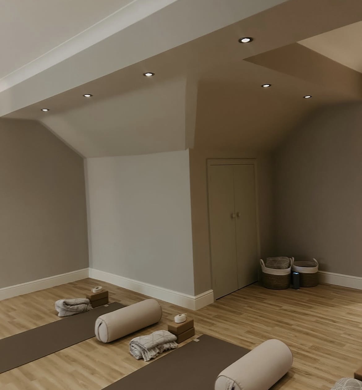 Yoga mats and props arranged in the studio, warm lighting